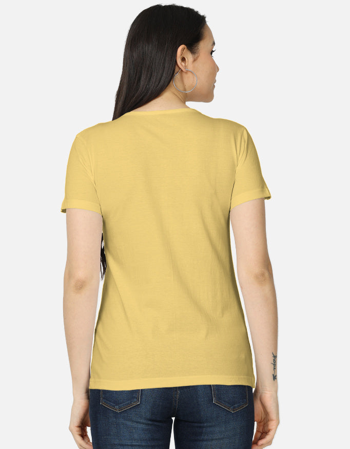 Backside view of the women's crew neck t-shirt. Model wearing a yellow 100% super-combed cotton t-shirt with a retro 70s golden hour sunset graphic print by Trendmelo.