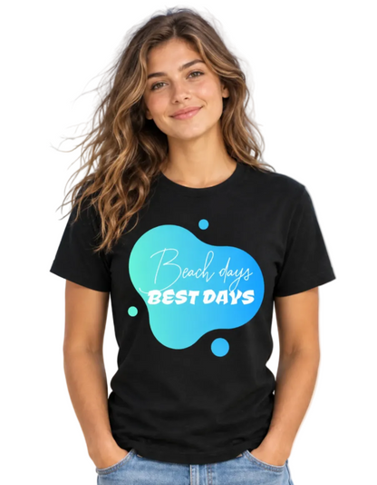 A woman with long wavy brown hair wearing a black t-shirt with a blue and teal graphic that reads 'Beach days BEST DAYS' in white script and block lettering, paired with light blue jeans, set against a plain white background.