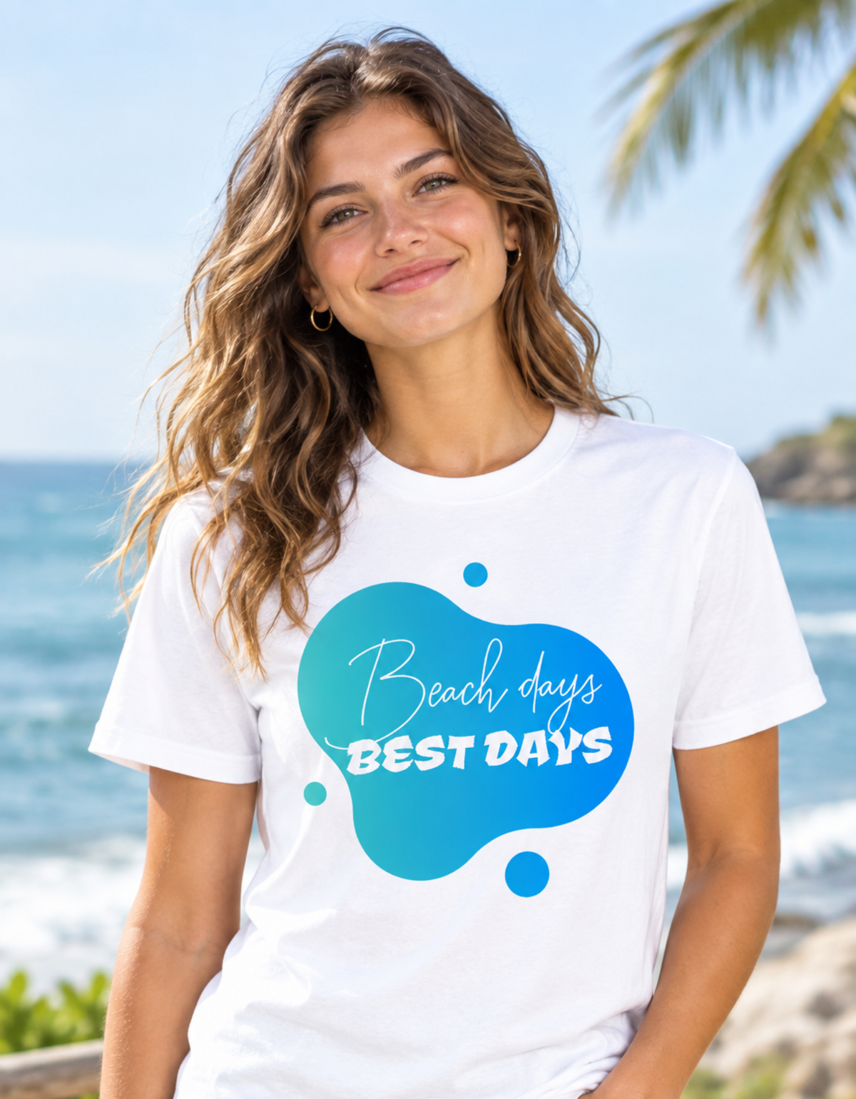 A woman wearing a white graphic t-shirt with a blue and teal abstract splash design that reads 'Beach days BEST DAYS' in white script and block lettering, set against a sunny beach background.