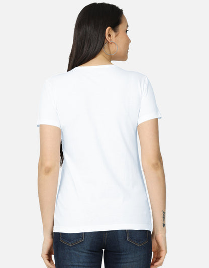 Backside view of the women's crew neck t-shirt. Model wearing a white 100% super-combed cotton t-shirt with a retro 70s golden hour sunset graphic print by Trendmelo.